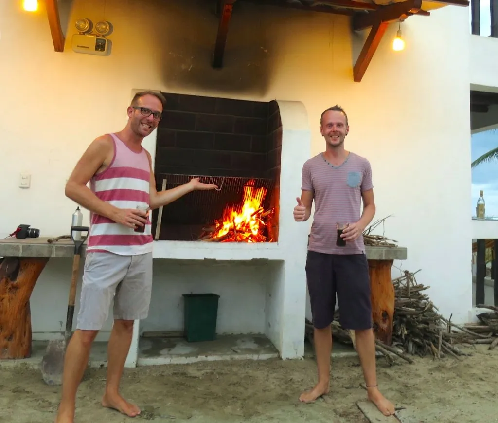 Guests beside the lit grill on an evening at Sundown Beach Hotel